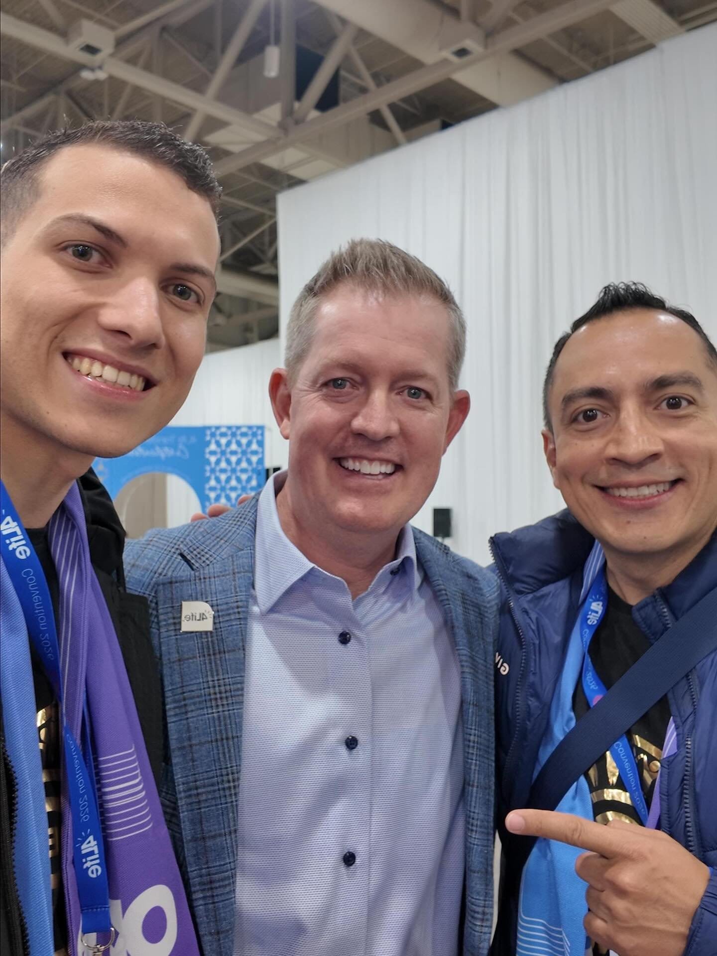 Galería de Éxito 4Life - Tres hombres con lanyards de evento techo industrial - Mentoría Global